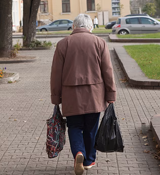 Photo of a woman in a brown coat with shopping bags