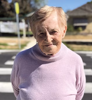 Photo of a woman in a pink jumper at a zebra crossing