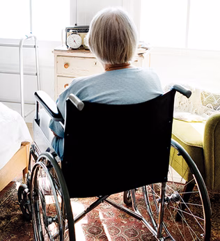 Photo of a woman in a wheelchair in a sunny room