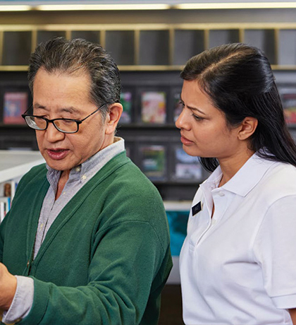 Photo of two people looking at books in a library