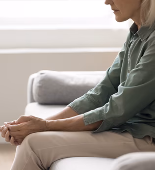 Photo of a woman in a green shirt sitting on a sofa