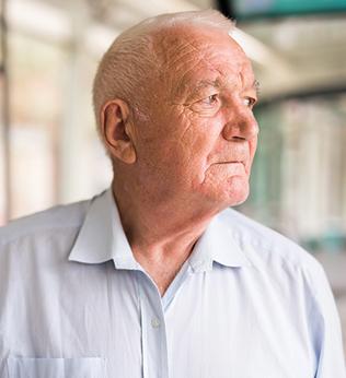 Photo of a man in a pale blue shirt on public transport