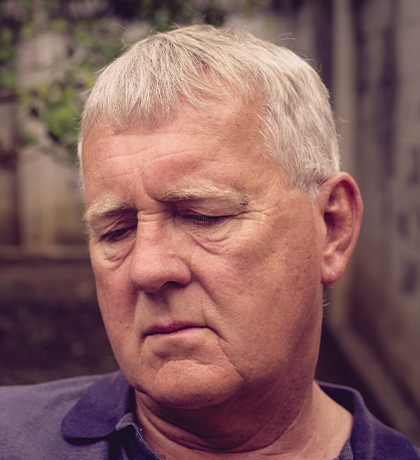 Photo of man in a courtyard wearing a purple polo shirt