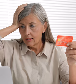Photo of woman holding credit card sitting at a laptop