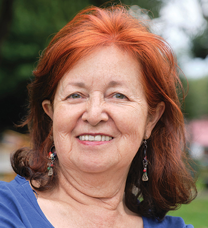 Photo of a woman with red hair outdoors in a blue top