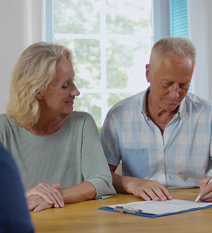 Photo of two people sitting at a table with paperwork