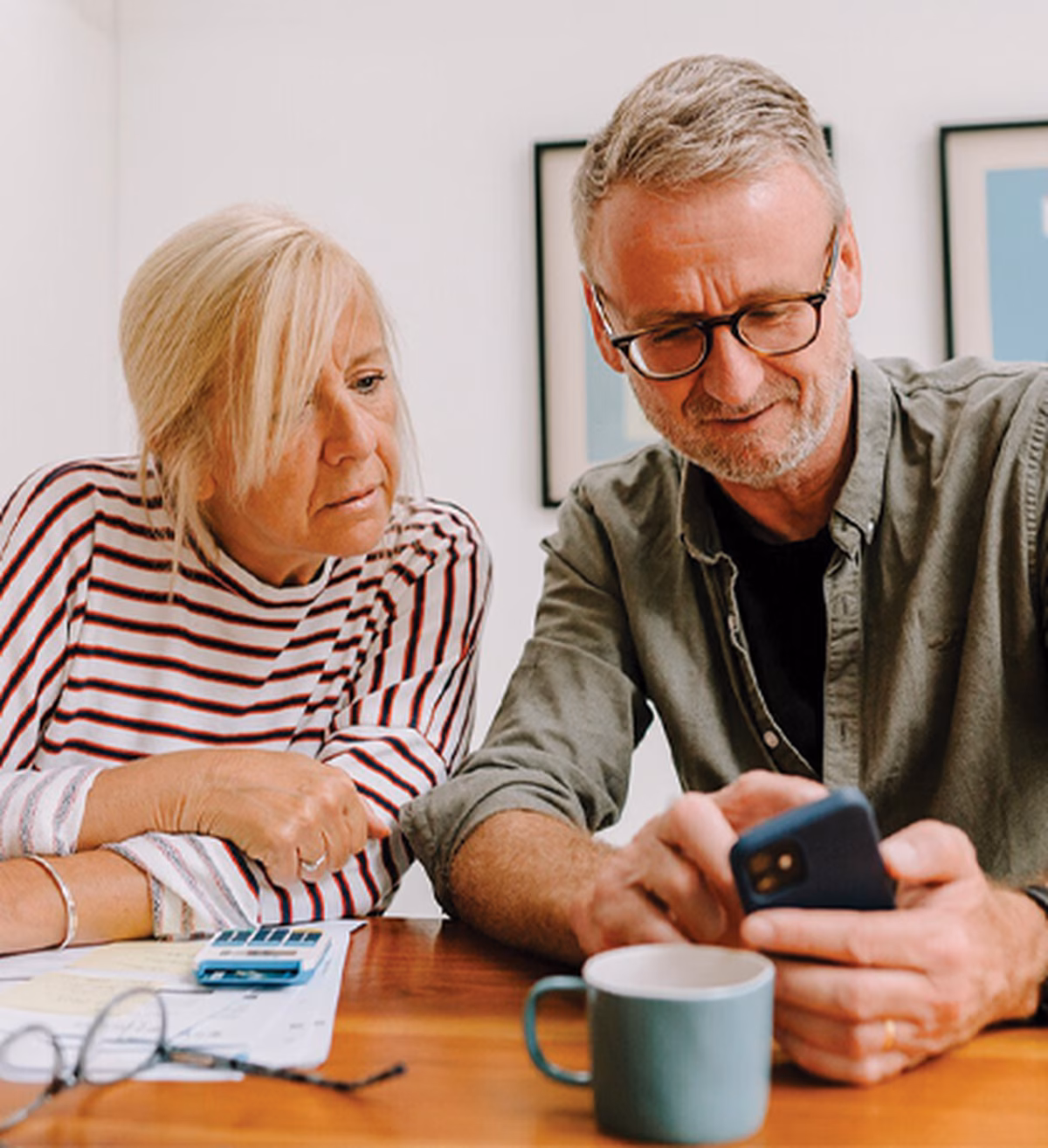 A woman and a man looking at something on a smartphone
