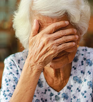 Photo of woman with white hair and her hand over her eyes