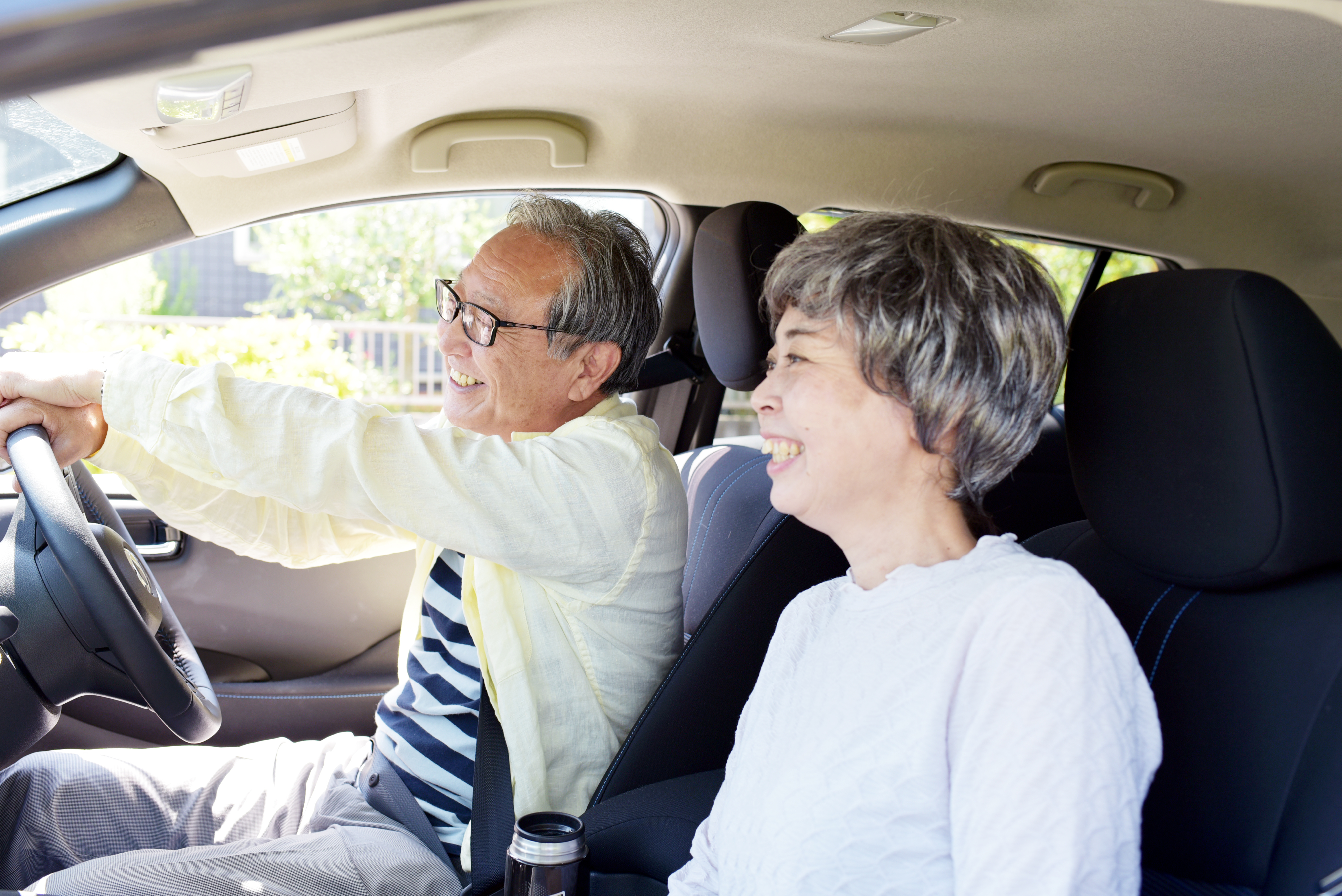 Mature Asian couple smiling in car