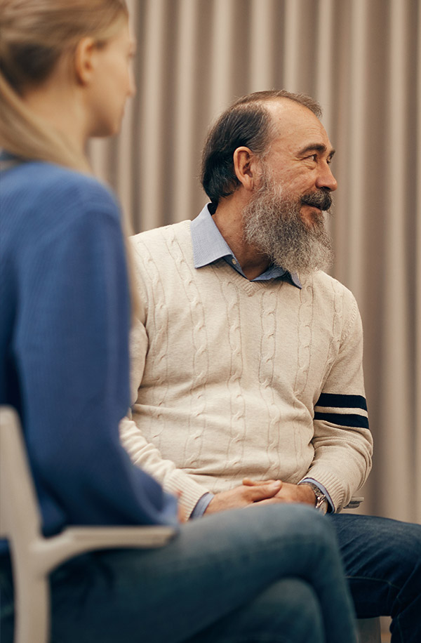 senior man with beard listening to someone
