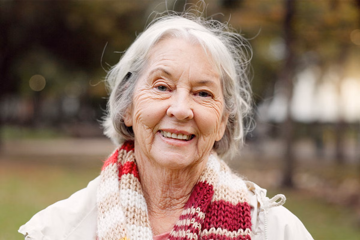 Image of an older woman wearing a red and white scarf