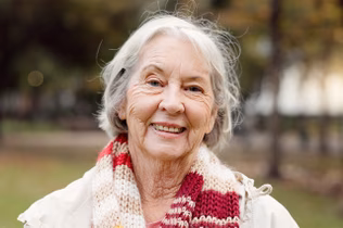 Image of an older woman wearing a red and white scarf