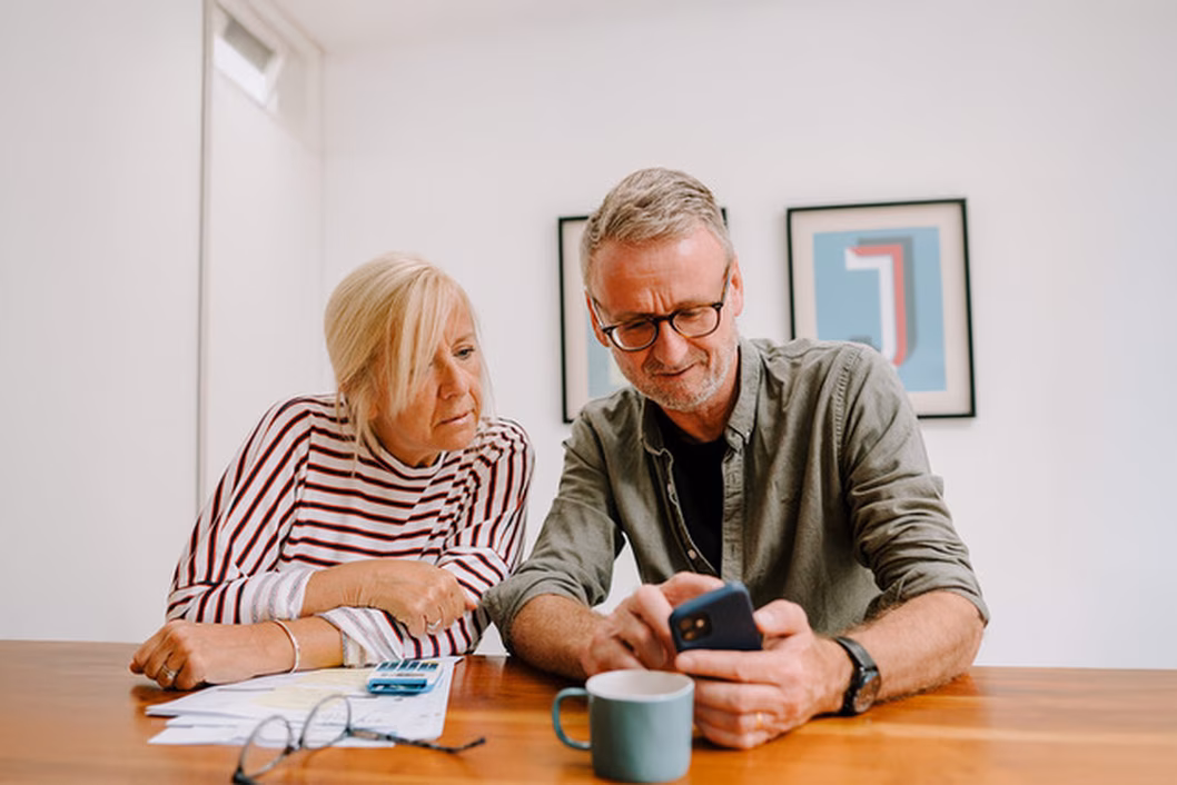Image of a man and a woman looking at something on a smartphone