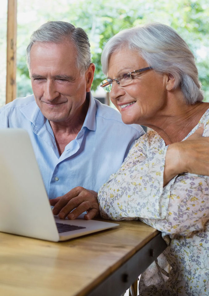 Senior couple sitting in front of laptop