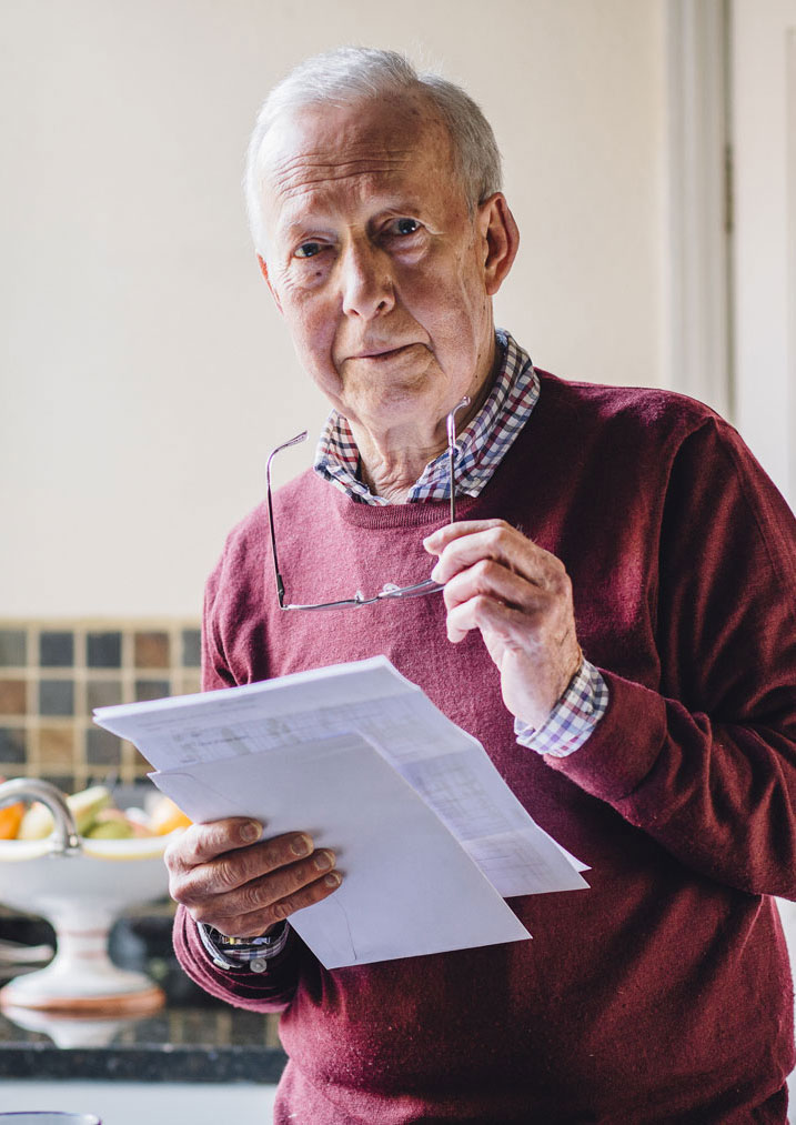 Senior man taking his glasses off after reading document