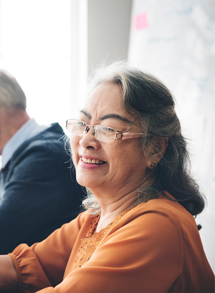 Photo of woman smiling in a burnt orange shirt