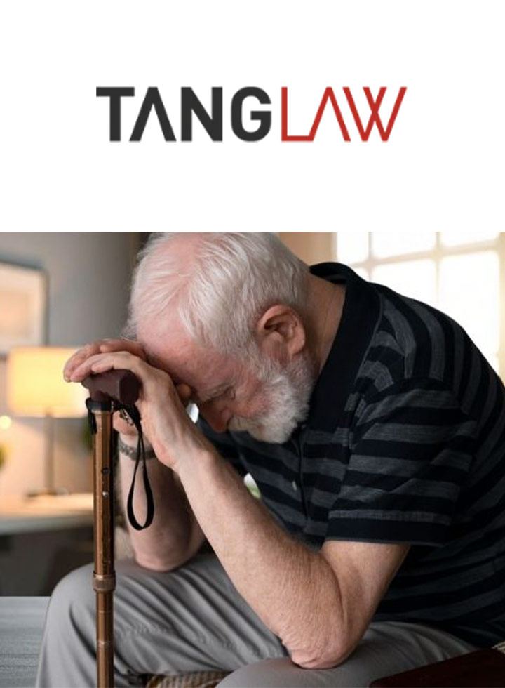 Photo of a man leaning his head on his walking stick