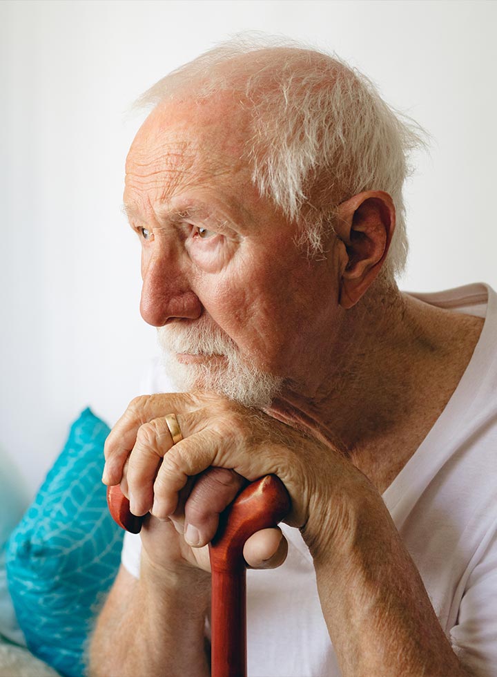 Photo of a senior gent with a walking stick and wedding ring