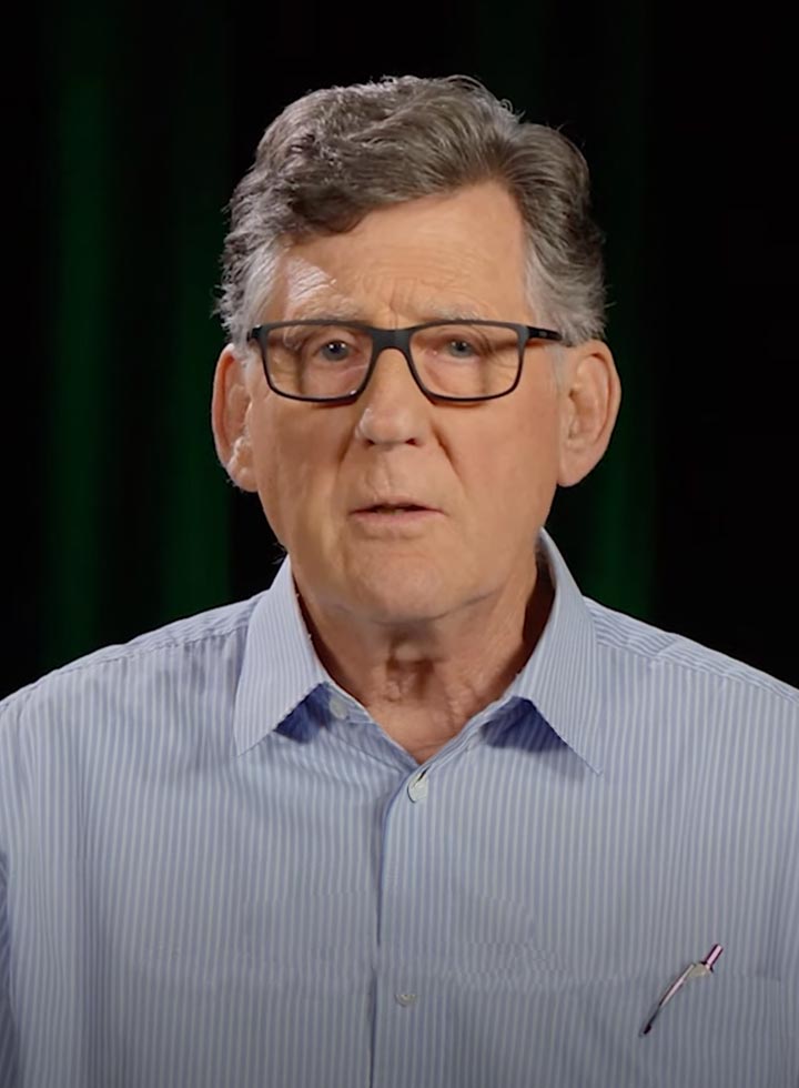 Photo of a man wearing glasses and a blue striped shirt