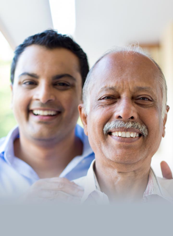 Photo of father and son smiling at camera