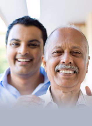 Photo of father and son smiling at camera