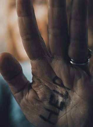 Photo of elderly hand with help written on the palm