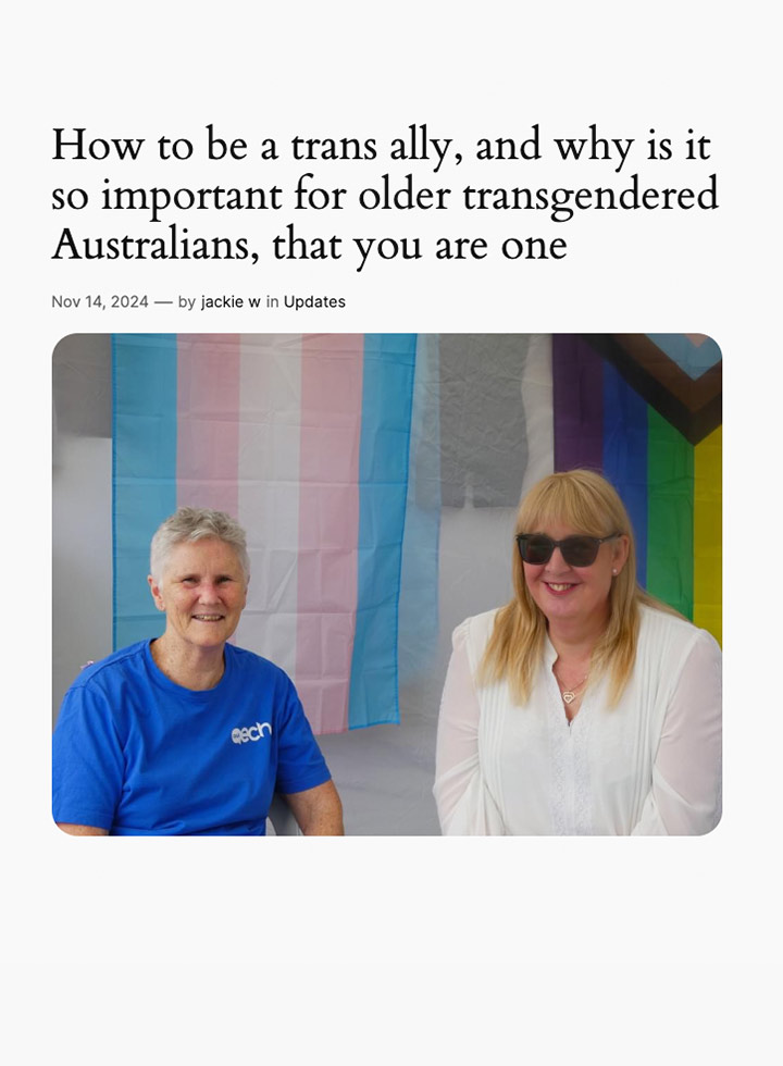 Two people sitting in front of the trans and rainbow flags