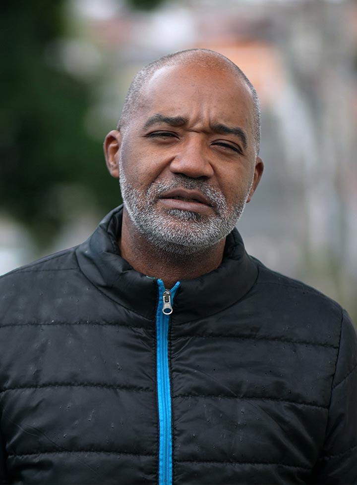 Photo of a man in a black jacket with a bright blue zip