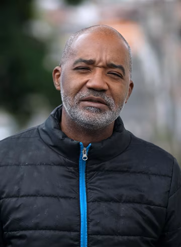 Photo of a man in a black jacket with a bright blue zip
