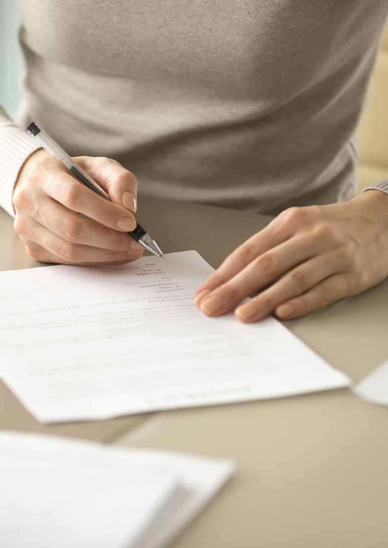 Close up of a woman's hands filling out forms