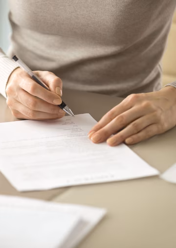 Close up of a woman's hands filling out forms
