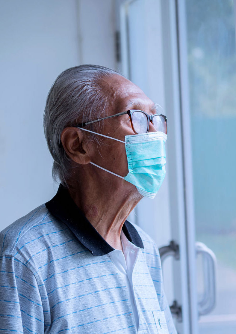 Elderly man looking out of window