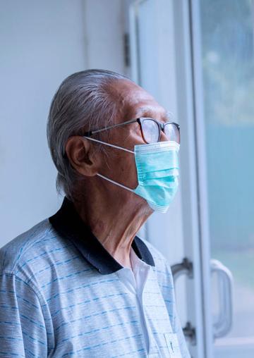 Elderly man looking out of window