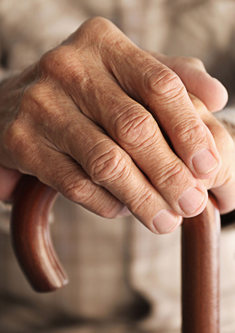 Mans hands on walking cane