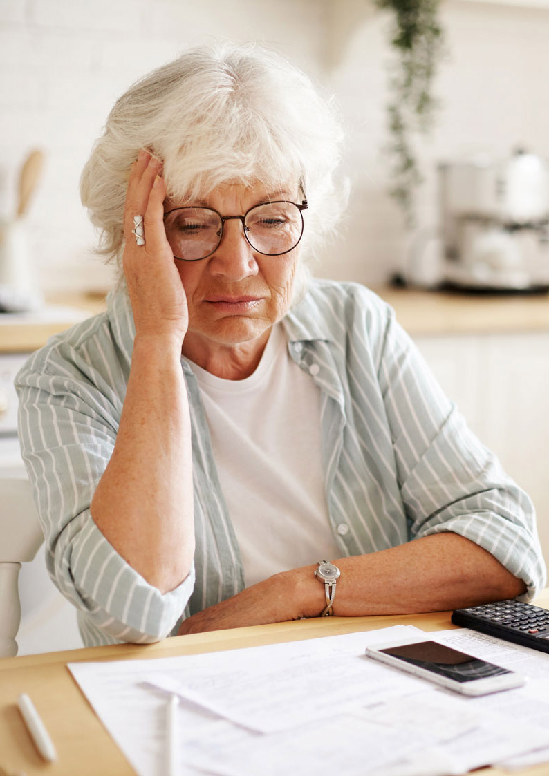 Stressed elderly woman with financial papers