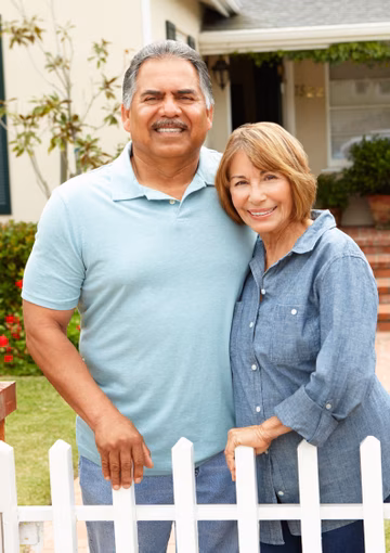 Couple standing out the front of their house 