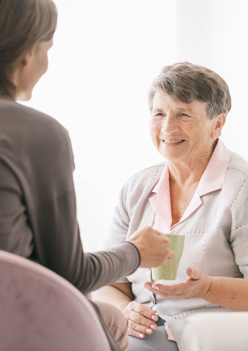 Senior woman having a cup of tea with adult child