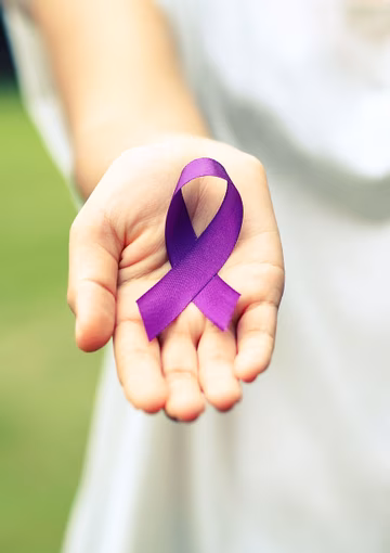 Hand holding out purple ribbon