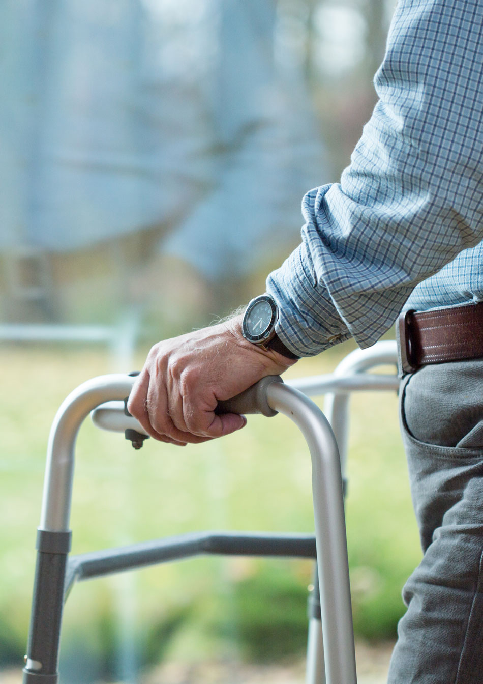 Senior man with a walker looking out of the window