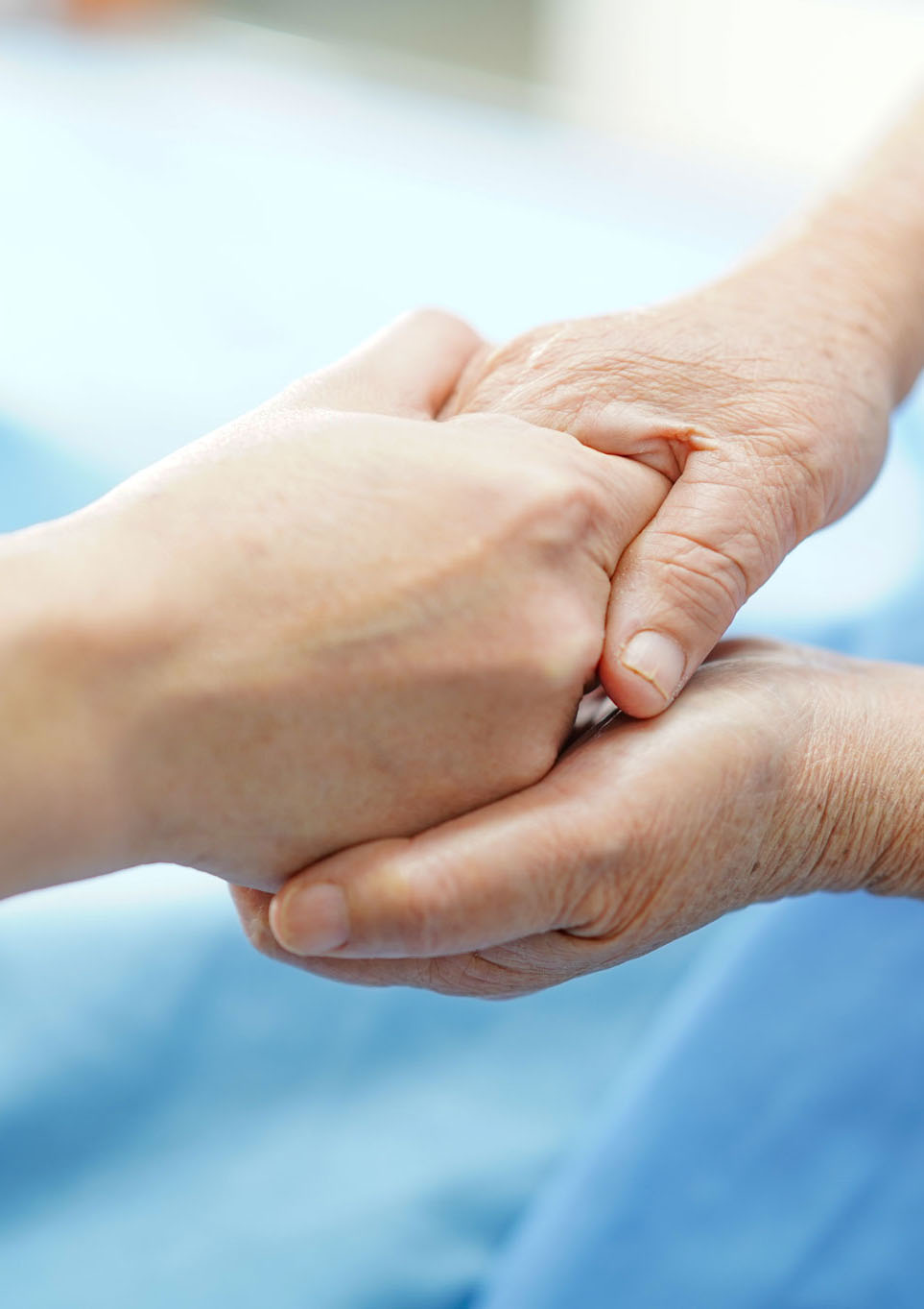 Elderly woman's hands being held