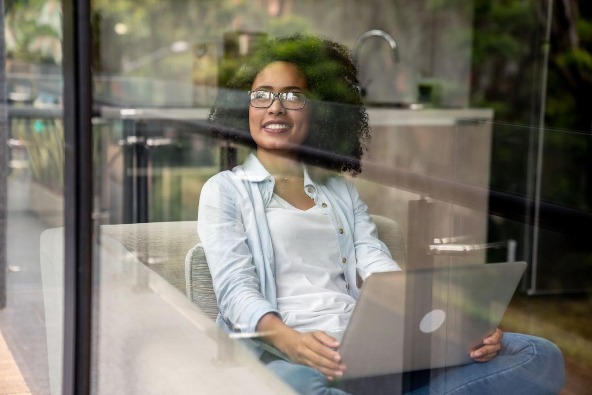 woman behind glass with laptop