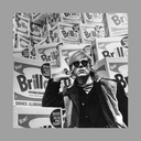 black and white photograph of Andy Warhol wearing sunglasses in front of a stack of Brillo boxes black and white photograph of Andy Warhol wearing sunglasses in front of a stack of Brillo boxes