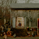 artist Maxwell Mustardo sitting on the doorstep of his studio with sculptures arranged on the steps outside artist Maxwell Mustardo sitting on the doorstep of his studio with sculptures arranged on the steps outside