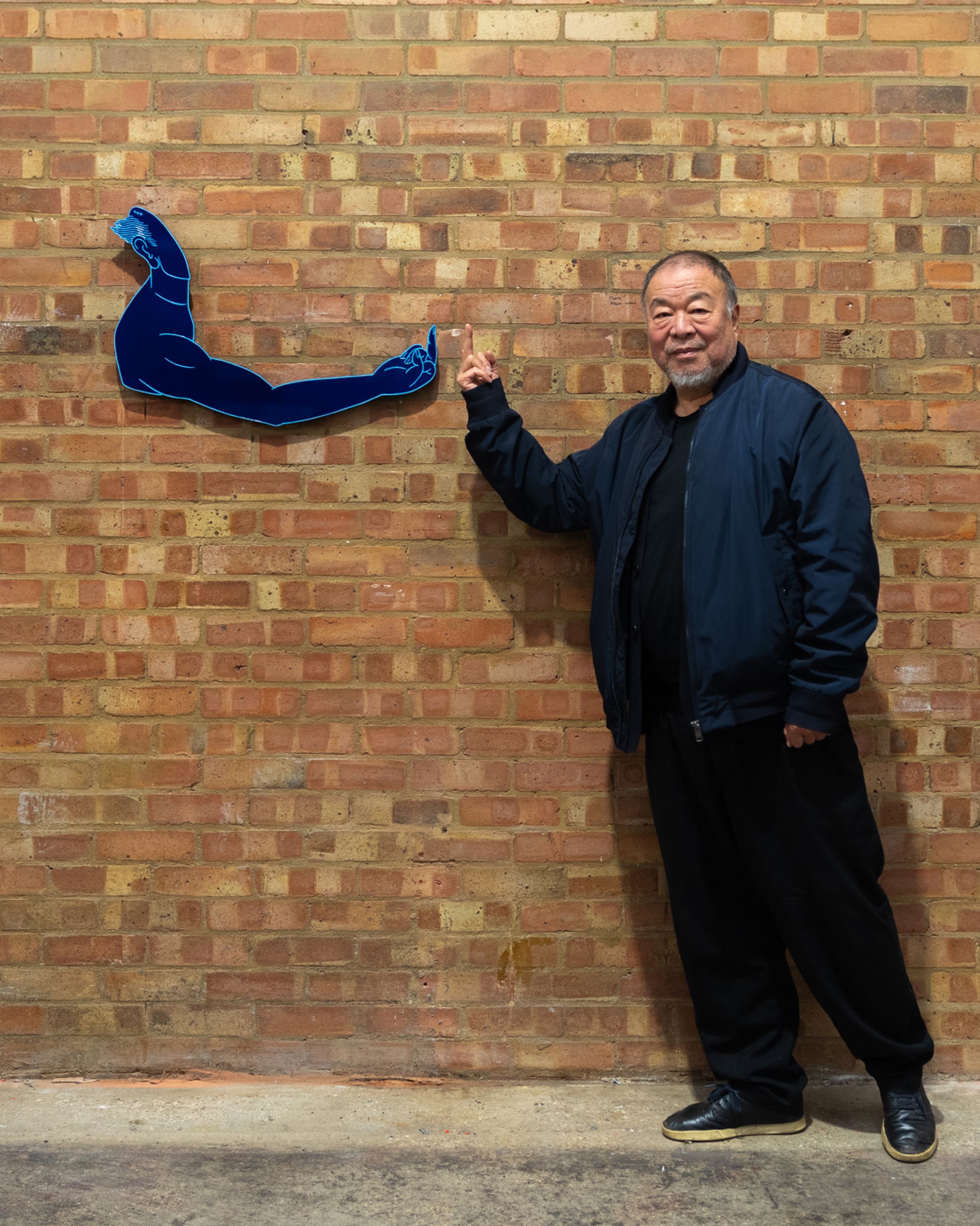 Artist Ai Weiwei standing next to his sculpture