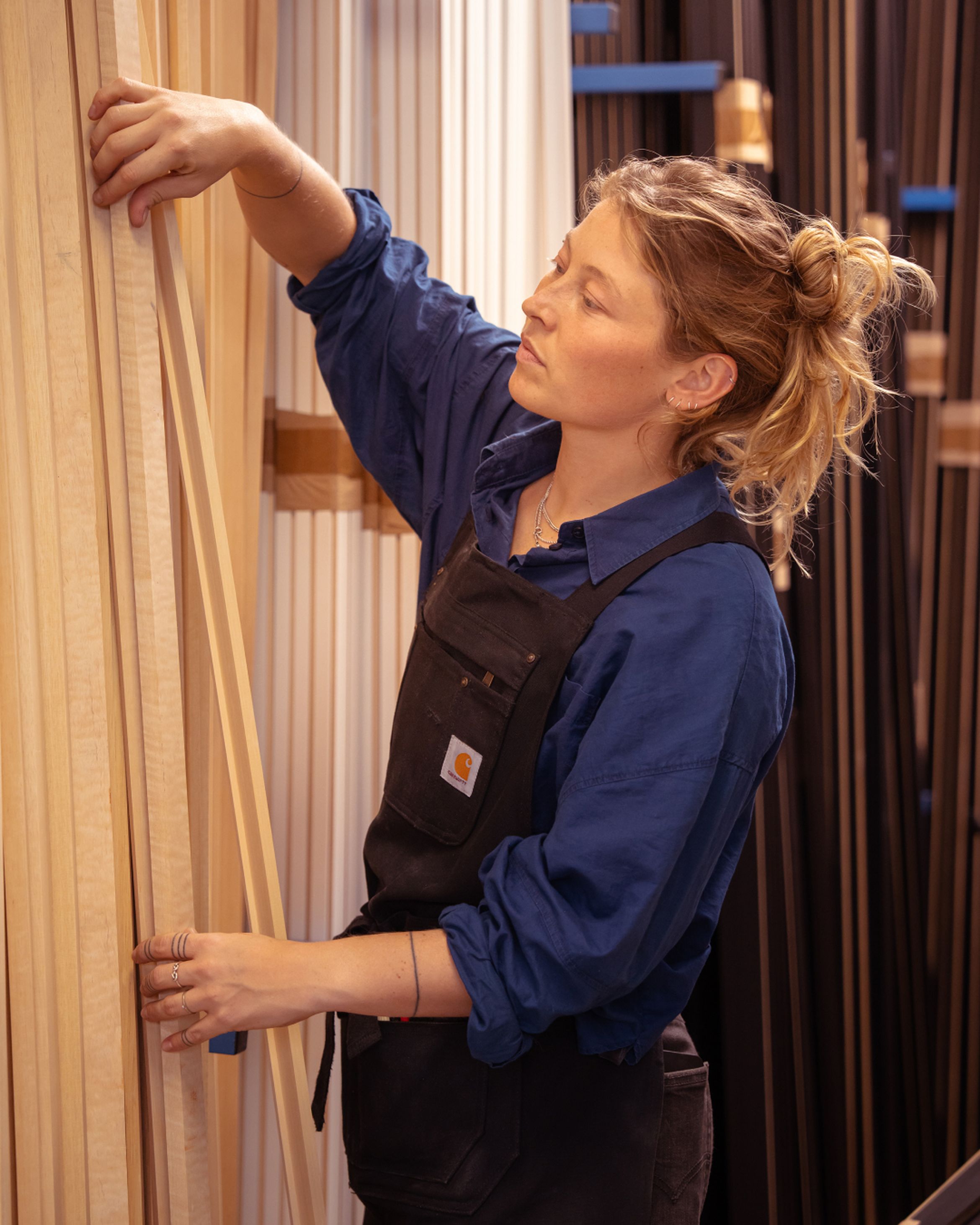 A portrait of master framer Roos at work in the framing studio