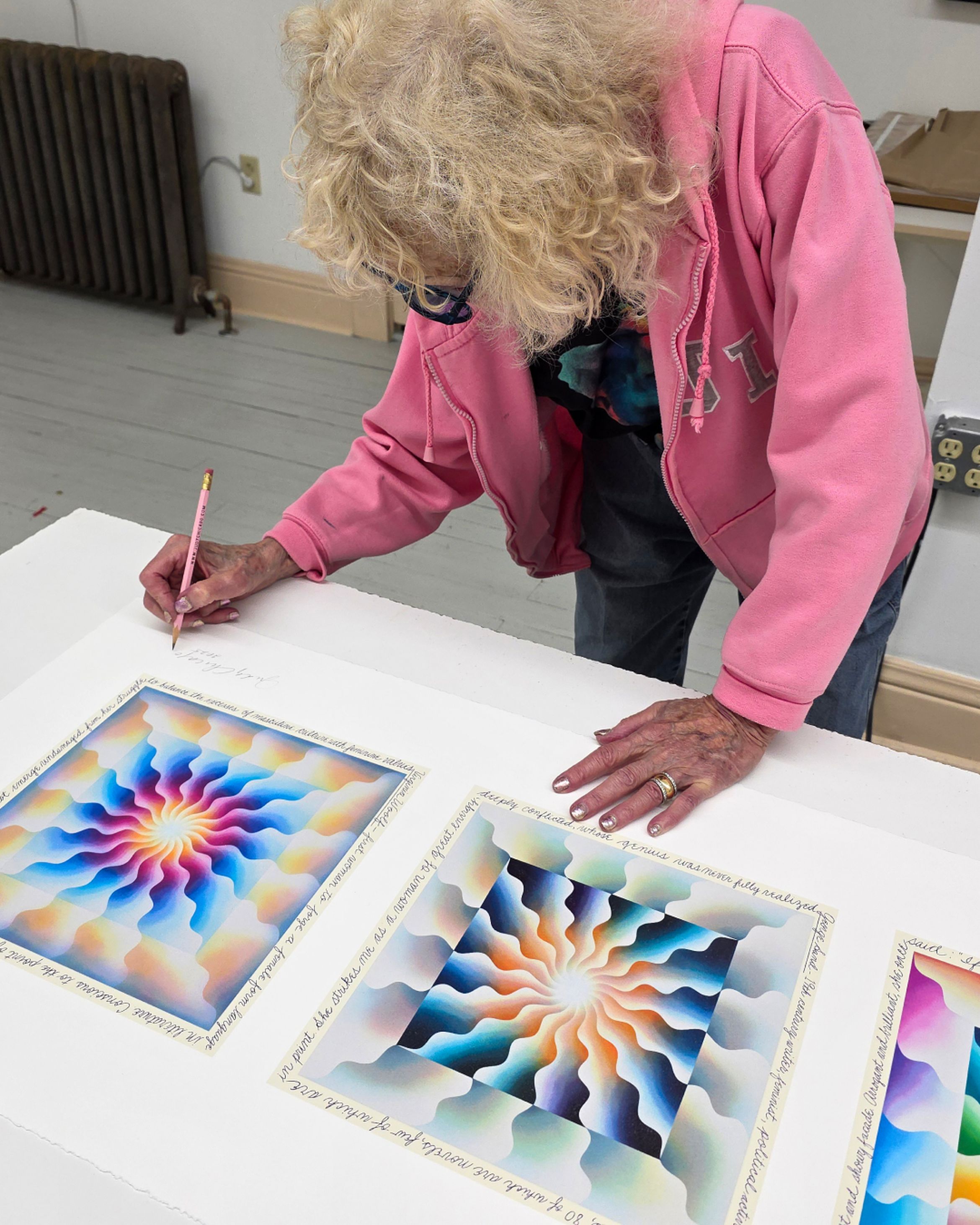 Artist Judy Chicago signs the limited edition 'Reincarnation Triptych' print.