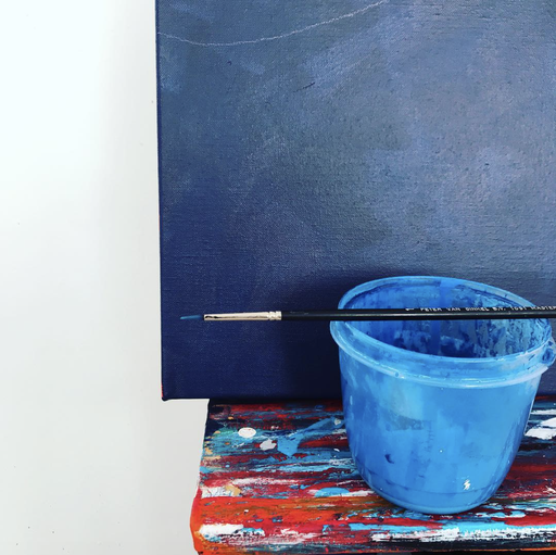 Close up of a paintbrush balancing on top of a water pot Close up of a paintbrush balancing on top of a water pot