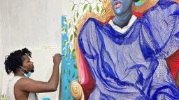 Adjei Tawaiah adding blue paint to a large, mixed media canvas Adjei Tawaiah adding blue paint to a large, mixed media canvas