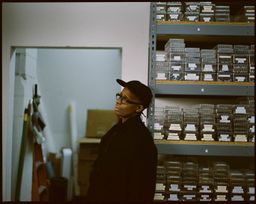 Mickalene Thomas leans against wall in studio filled with gemstones Mickalene Thomas leans against wall in studio filled with gemstones