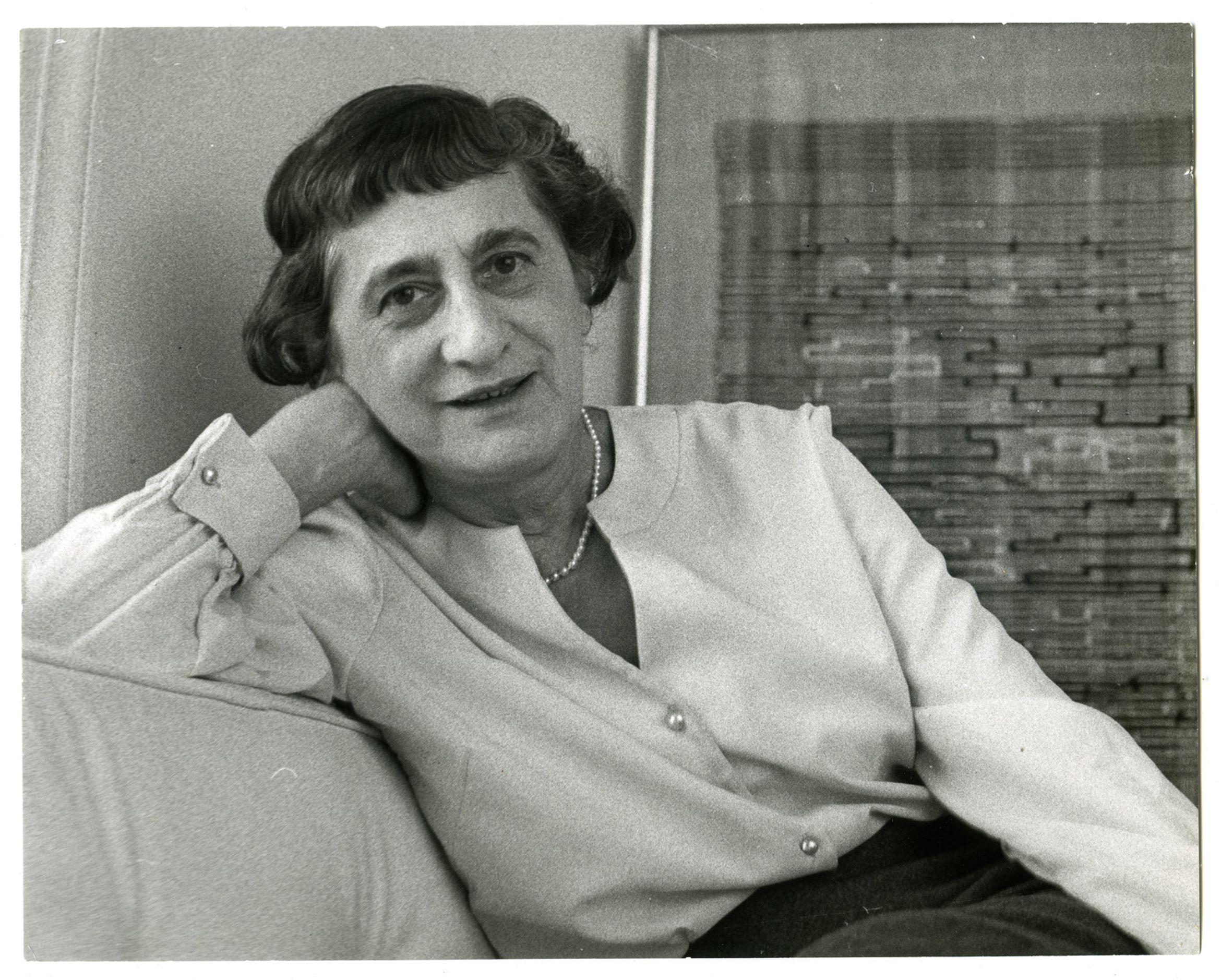 Black-and-white photograph of Anni Albers, textile artist and designer, seated in front of a weave.